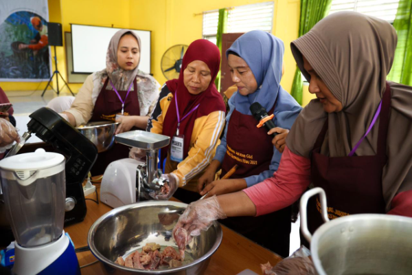 Peserta pelatihan program TJSL PalmCo mengikuti praktik pengolahan ikan lele menjadi produk bernilai tambah di Kabupaten Kampar, Riau, sebagai bagian dari upaya pemberdayaan perempuan dan penguatan ekonomi lokal.