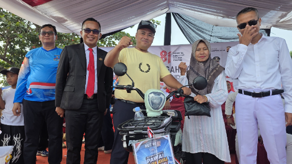 H. Riki Suhendra menyerahkan hadiah sepeda listrik kepada salah satu peserta dalam rangkaian kegiatan HUT ke-81 Republik Indonesia dan HUT ke-25 Partai Demokrat di Anyer, Kabupaten Serang, Minggu (23/8/2026).